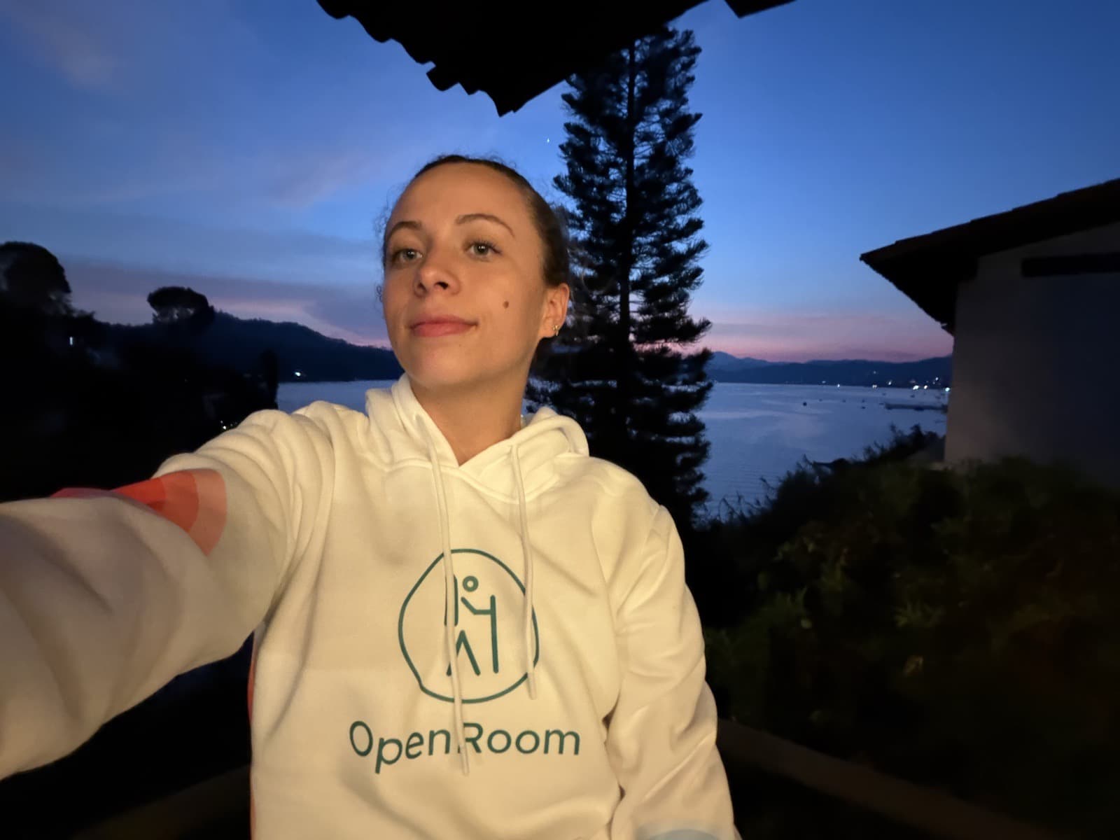 OpenRoom ambassador wearing a branded hoodie at sunset