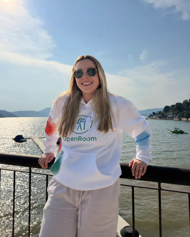 OpenRoom brand ambassador wearing a white hoodie by the lake