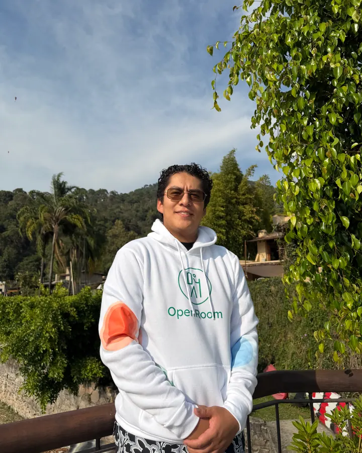 OpenRoom brand ambassador wearing a white hoodie with mountains behind him