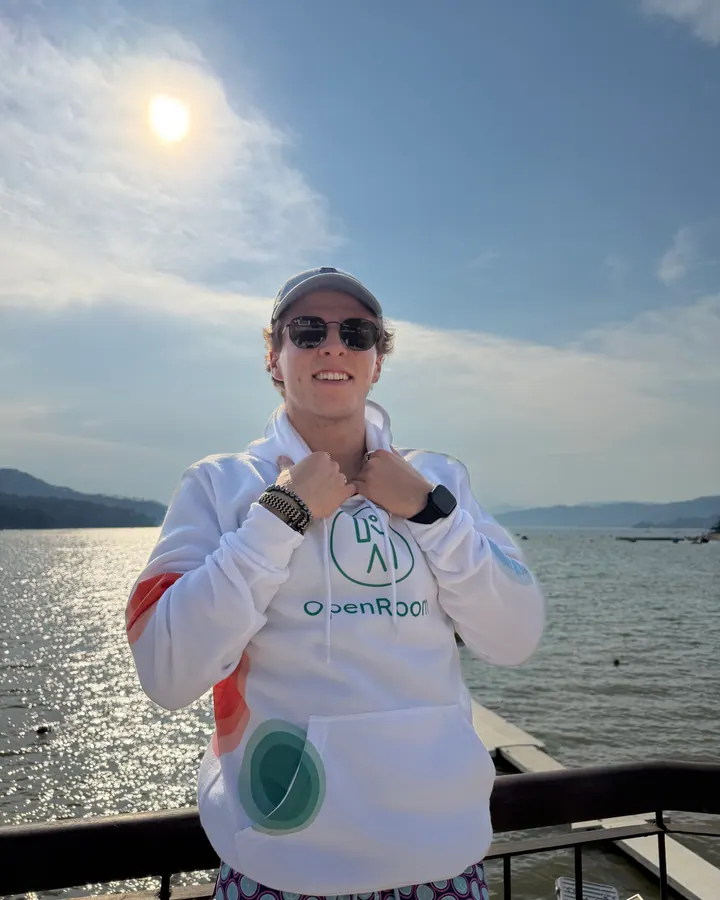 OpenRoom brand ambassador posing in a hoodie near the water